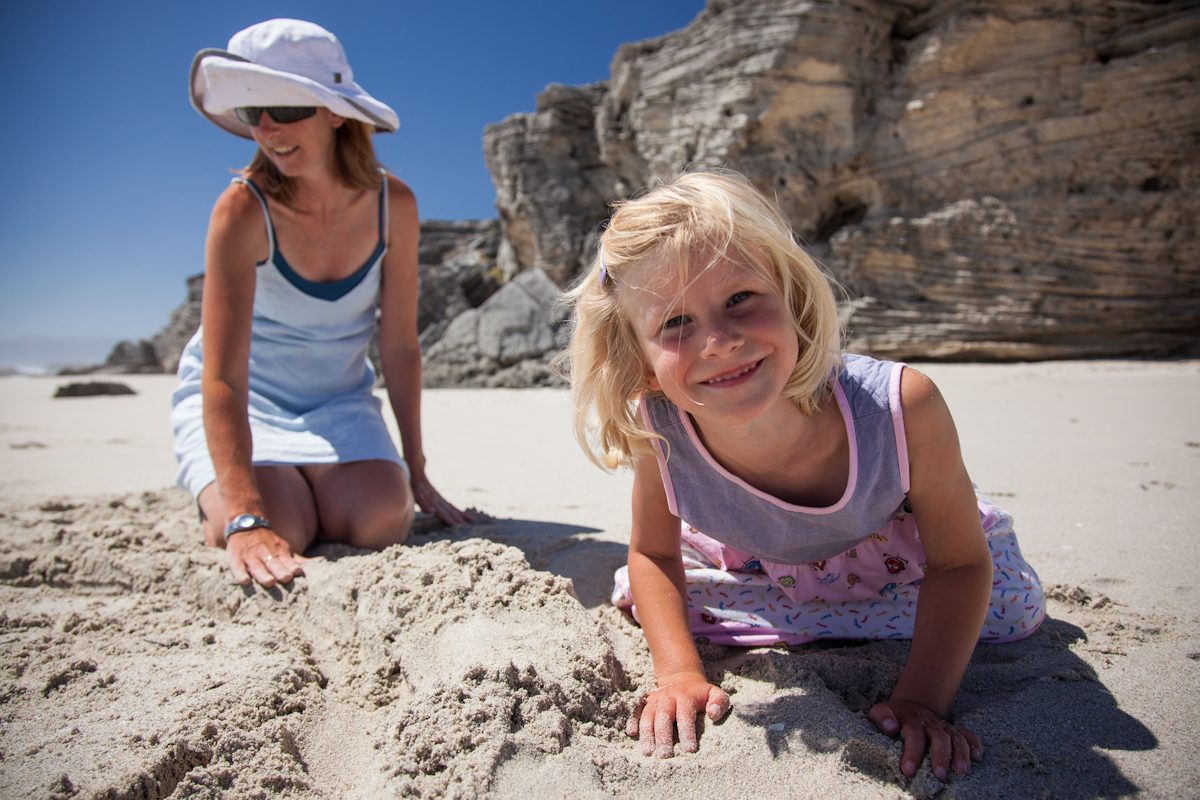 Mom and daughter sitting on the beach