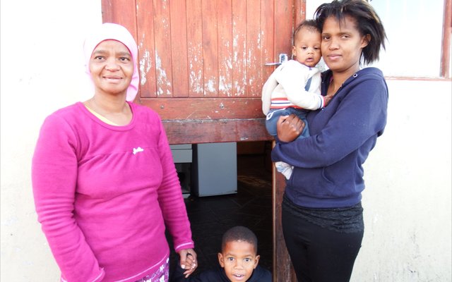 Vlnr is Elsa Europa en Elwida Damons en haar baba van drie maande, met  klein  Waldy Europa wat voor sit, by die agterdeur van Elsa se woning waarvan die onderste helfte uitgebreek is