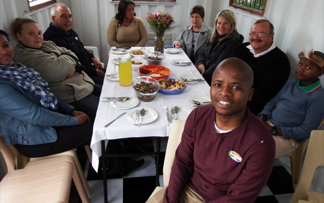 Regs voor sit ‘n trotse Ally Msweli tydens die amptelike opening van sy eie toerbedryf in Masakhane, Masakhane Township Tours, saam met van die gaste wat die opening bygewoon het.