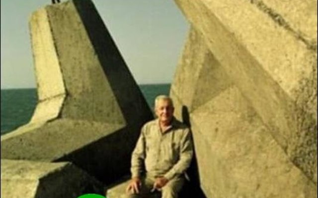 ‘n Trotse Aubrey Kruger, ontwerper van die dolos, sit hier in Oos-London hawe tussen sy uitvindsels.