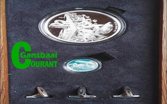 Die gemonteerde R2 en 2½c silwermuntstukke, met dolosafdrukke daarop, waarmee Aubrey Kruger enkele weke voor sy afsterwe deur die Suid-Afrikaanse Munt vereer is.  