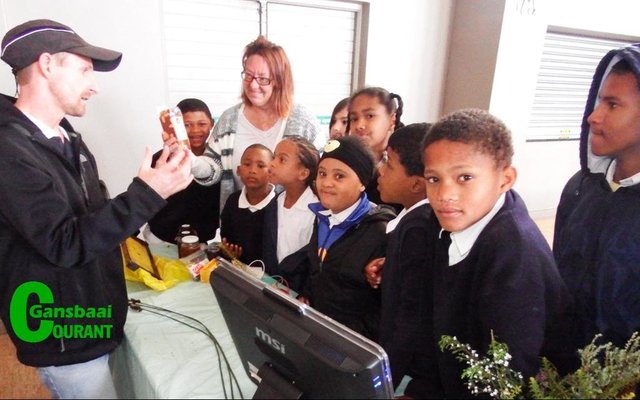 Christoff Longland van Whale Coast Conservation beklemtoon die ekonomiese waarde van Fynbos aan Gansbaai Primêr se leerders,  met Marieta Rademeyer van die skool wat toekyk.  