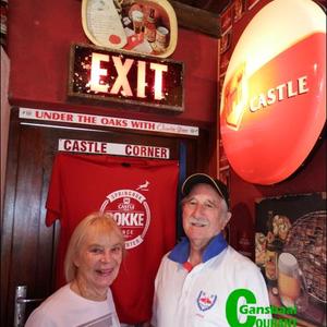 David MacDonald, host for the craft beer tasting in his house, with his wife, Margaret in his own “Castle Corner” with the EXIT sign from the Newlands Cricket Legends Grounds, which forms part of his private collection.  