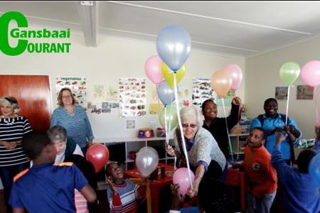 Die ballonne wat die Wacky Whalers Kwiltgroep na Gansbaai Elimhuis gebring het, het meer aandag as die lekkernye getrek. Voor is Olga Swanepoel, sameroeper, besig met die uitdeel van ballonne. 