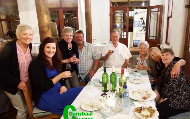 ‘n Groepie vrolike wynproewers tydens Gansbaai Wynproegilde se jaarafsluiting. Vlnr is om die tafel is Molley van der Colff, Nelleke van der Brugge, Diane Roodman, Theuns Roodman (voorsitter), Daan Oosthuizen (tesourier), Petro Oosthuizen, Sunet Heyns en Anita Botha.