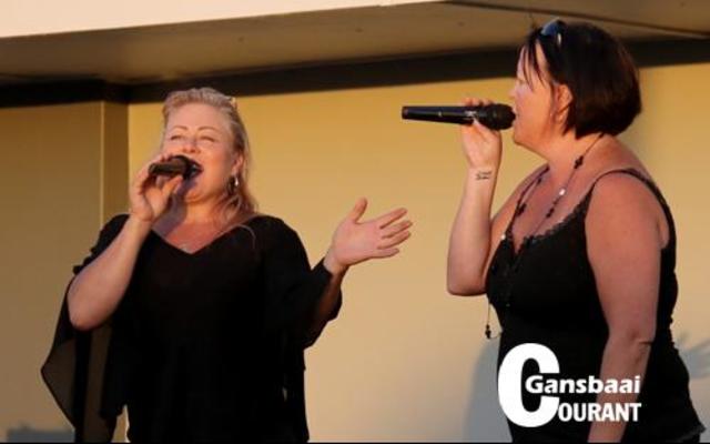 Gansbaai  se welbekende sangpaar Jamboree met Tania Greeff en Natasha Herholdt agter die mikrofoon tydens die aanskakeling van die dorp se Kersliggies.