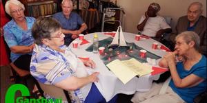 Links om die tafel is Emily Macaulay, Suster Linda Meyer, Hughie Macaulay, Sarah Damon, Kowie de Wet en Marina Esterhuizen tydens die gesellige Kersfunksie.