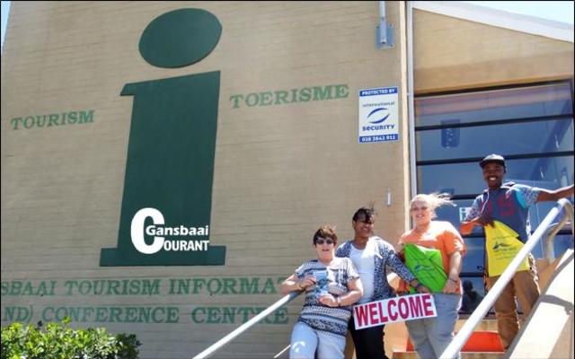 Die span by die Gansbaai Toeriste- en Inligtingsentrum is hier wel windverwaaid, maar staan slaggereed vir besoekers aan ons dorp. Van links Glenda Kitley (bestuurder), Maureen Valentine, Doulene Els en Akhona Jordaan.  Die sentrum is langs die Great White Junction (Superspar) winkelsentrum geleë.