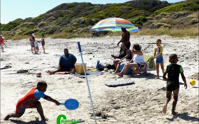 Nolene Kini van Richmond  vertel dat dit hulle eerste vakansie in Gansbaai is.  Hulle is verlief op die plek en gaan vir twee weke tuis in ‘n vakansiehuis in Kleinbaai.  Op die oomblik kyk hulle uit vir ‘n erf om te koop, want hulle wil vir die res van hul lewens hul twee weke vakansie hier kom spandeer.  Die besige twee seuntjies op die voorgrond is haar seuns, Ethan en Angelo.  Shaun October, ‘n familie-vriend vanuit Victoria-Wes staan links met Akhona Kili, Nolene, Zelda October en Shane October regs.