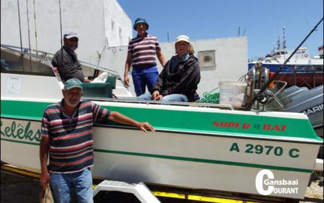 Skipper Jean Downing staan voor sy boot, Relêks II, met sy bemanning vlnr op die boot Bertus Prins, George Rowan en Philip Fourie ná hulle hengeldag op see.