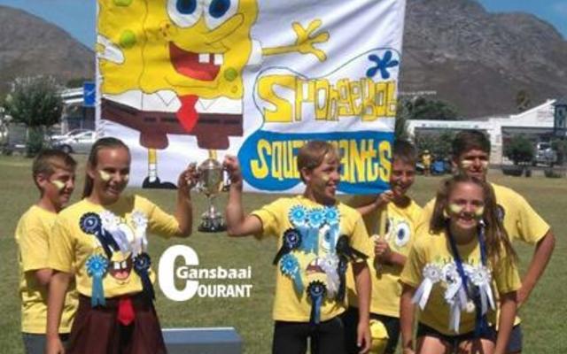 Die opgewonde Geelspan (die “SpongeBob SquarePants”), wat die punte-beker gewen het, se spankapteins, Monique Hugo (dogters) en AJ Bosch (seuns) hou die beker trots vas. Saam met hulle is van links Christoff Dahl, Nieldré Groenewald, Charl Eksteen en Nadine Groe-newald. George Groenewald en Casey Foster verskyn nie hier nie.