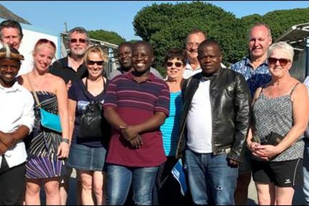 The tourists from Belgium were very pleased with the entertainment in Masakhane, as well as the Masakhane Tour, presented by Ally Msweli (middle front). With them are several guests from Gansbaai.   