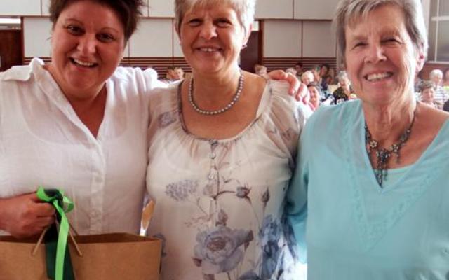 Lindie Stander (links), formidabele gasspreker tydens die NGK se Vrouediens ontvang ‘n geskenk van Adele Swart, sameroeper en Sankie Prinsloo, die programleier.