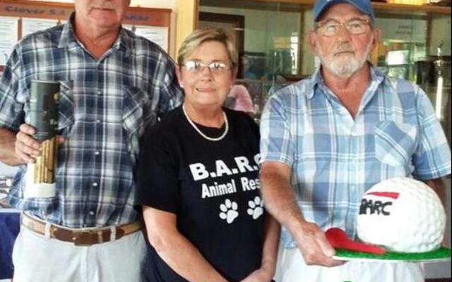 Bev Swart (links), wat die veiling hanteer het tydens BARC se gholfdag, staan by Annatjie Jonker van BARC en Piet Schoombie wat die hoogste op die gholfbalkoek gebie het.