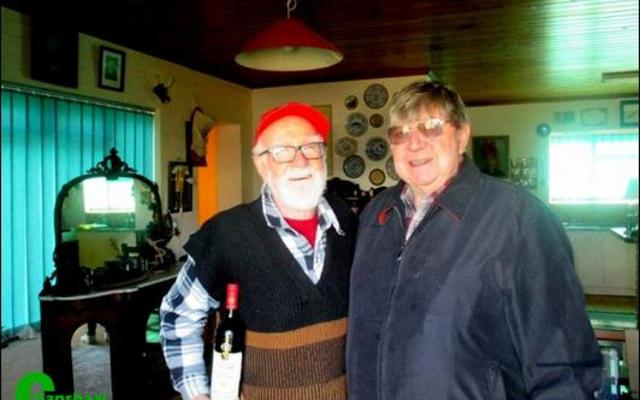 Links ontvang die 91-jarige kaptein Willem van der Merwe sy bottel rooiwyn met die eiendomsagentskap se etiket daarop, van Petrus du Preez, die agent wat die transaksie beklink het.  Petrus self raak-raak aan 80 jaar. 