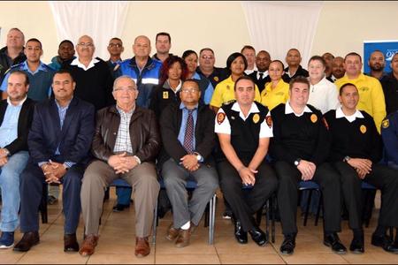 The Overstrand Fire Department recently hosted an end of fire season debriefing session at the Pringle Bay Community Hall. Front fltr Overstrand’s Cllr Fanie Krige (Kleinmond), Cllr Grant Cohen (Kleinmond), Neville Michaels (Director:  Protection Services), Coenie Groenewald (Municipal Manager), Cllr Arnie Africa (Portfolio Head:  Protection Services), Lester Smith (Chief:  Fire, Rescue and Disaster Management), Marlu Rust (Snr Disaster Management Officer) and Angelo Aplon (Ass Chief:  Fire, Rescue and Disaster Management). The large group at the back included officials of the Overstrand Traffic, Fire and Law Enforcement, Overberg District Municipality, Greater Overberg Fire Protection Association, City of Cape Town Fire and Rescue, CapeNature, NCC Environmental Services and Provincial Traffic.