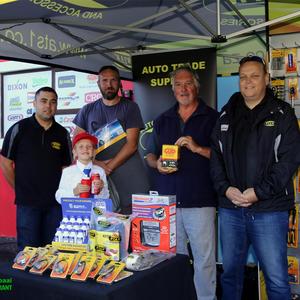 Elke kliënt is Vrydag tydens Autopart se opening met ‘n geskenk, Coke of worsbroodjie getrakteer.  Grant Gavin (Auto Trade Supplies) staan hier by ‘n gelukkige wenner, Theunis Scholtz en sy dogtertjie, Angelique wat in haar noppies was met haar hoedjie, waterbottel en blikkie Coke, saam met Lonnie Roos van Groeneweide wat ook ‘n geskenk losgeslaan het.  Gavin Nash (Auto Trade Supplies) staan heel regs.