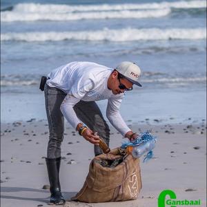 A volunteer taking part in the clean up day from Franskraal to Die Gruis collects a bottle. It is estimated that approximately 635,000  tonnes of rubbish enters our oceans every year.