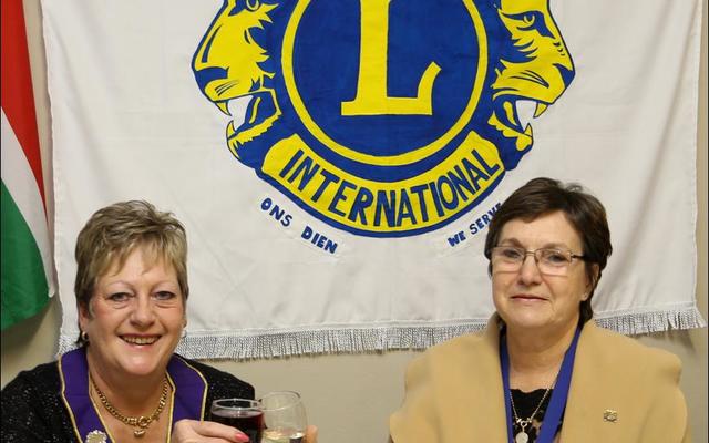 A  newly  painted  flag  for  a new season at the Gansbaai Lions  Club.   Past  District Governor, Paula Lang  and  Marietta  Hatting  toast on  the  success of  the  2017/18 season.