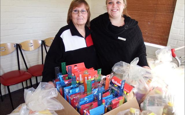‘n Dankbare Melody Scheepers (links) van Gansbaai Helpende Hand het onlangs ‘n groot hoeveelheid skryfbehoefte-stelle en voedselpakkies in ontvangs geneem wat deur Doulene Els (regs) van Gansbaai Toerisme georganiseer is.