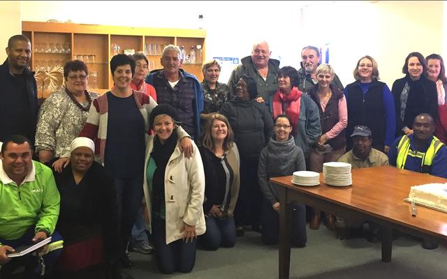 Hierdie groot groep Gansbaai munisipale beamptes kon nie wag dat Gilbert (Boetie) Hart se 19de verjaardagkoek gesny word nie, met Kat Myburgh, Areabestuurder, wat regs agter staan.