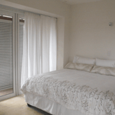 The master suite features a private balcony with shutters, walk-in-closet, and en suite bathroom with bath, shower and his and hers basins