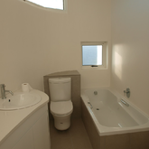 The master suite includes a light-filled, spa-like en suite bathroom with an extra-long bath, glass-enclosed shower and his and hers sinks