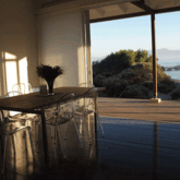 The teak dining room table seats eight on minimalist chairs and you can dine with an expansive view of the bay