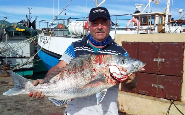 Oubaas_with_White_Steenbras_caught_off_Gansbaai_new_harbour_wall_in_storm_sea_1602843773