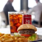 Xplorio™ Struisbaai - Catch Cook Restaurant - 200g Local grass fed beef burger served on a toasted sesame bun with tomato, lettuce, house sauce and chips. Add toppings: - caramelised onions- cheddar, mozzarella, feta- cheese sauce, garlic sauce, avo