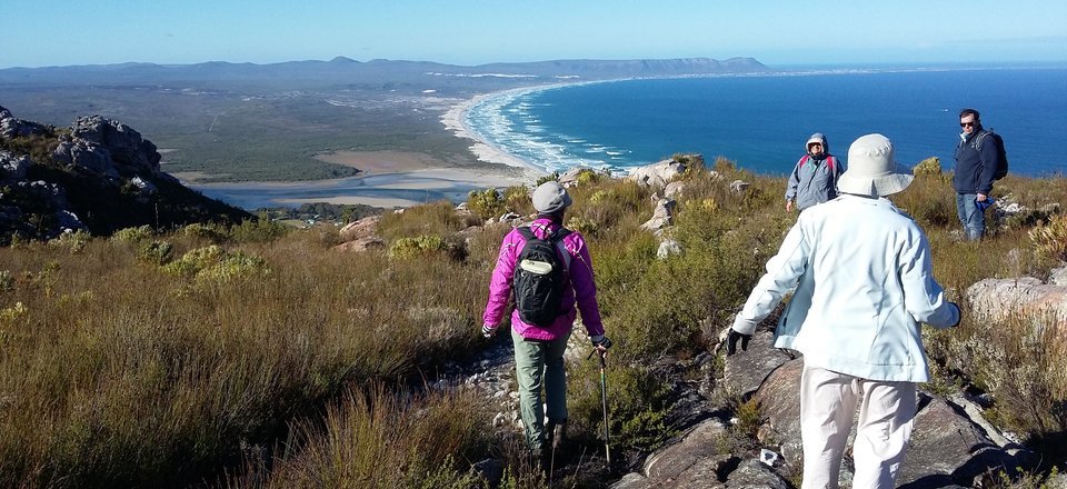 People hiking on the mountain with Grotto Beach almost showing 
