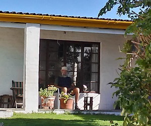 Die oupa sit op die stoep